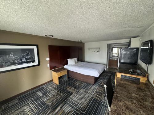 シャロンビルにあるRodeway Innのベッドと薄型テレビがあるホテルの部屋