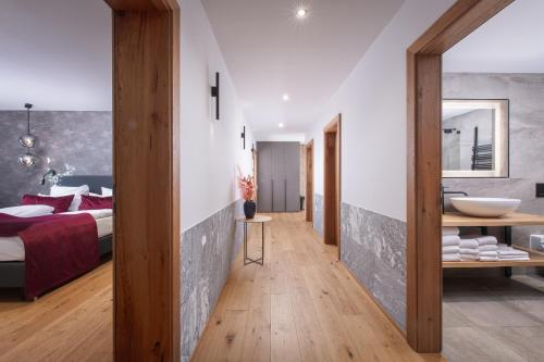a bedroom with a bed and a bathroom with a sink at Luxury Apartments "R6 Tegernsee" in Bad Wiessee