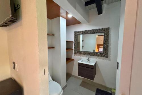 a bathroom with a sink and a mirror at Antema Lodge Secteur Tamarindo, piscine, yoga, gym, jungle et paix in Tamarindo