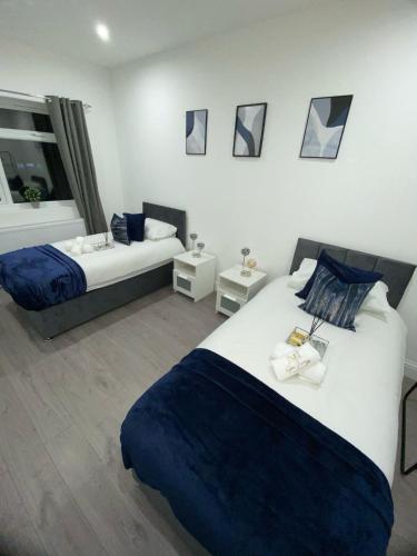 a hotel room with two beds and a mirror at Luxe Apartment in Croydon