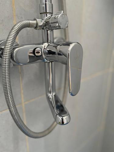 a chrome shower faucet in a bathroom at Casa de Brisa BnB in Prampuan