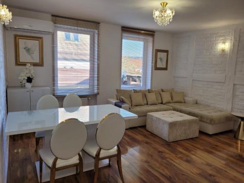a living room with a couch and a table and chairs at Portofino Apartamenty in Ustka