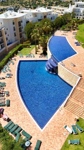 an overhead view of a large swimming pool with chairs at Modern Ocean, Garden & Pool view Condo by BeCherish in Albufeira