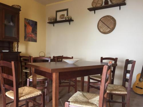 a dining room with a wooden table and chairs at Il Muraglio in Belmonte Calabro