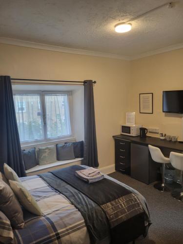 une chambre avec un lit, un bureau et une fenêtre dans l'établissement Station Guesthouse - key pad entry with parking, à Lancaster