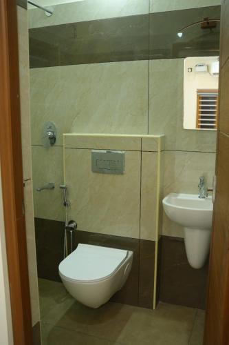 a bathroom with a toilet and a sink at Joen homes apartment in Alwaye