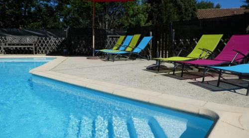 a group of lawn chairs and a swimming pool at Les Cades in Labeaume