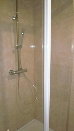 a shower with a hose in a bathroom at Hôtel L'Européen in Tarbes