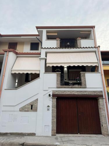 a white house with a brown garage at Casa Baronia in Assemini