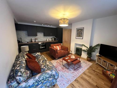 a living room with a couch and a table at Old Betting Shop for 3 & Furry Friend in Hayfield