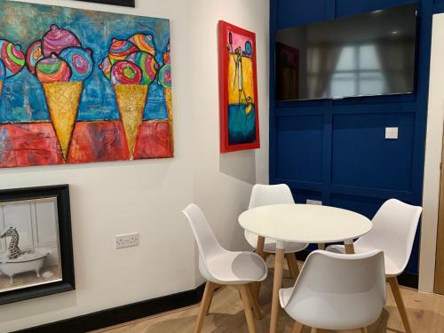 a dining room with a table and chairs and a painting at Luxury Guesthouse by The Hive WA1 in Warrington