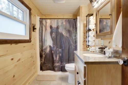 a bathroom with a shower with a bear shower curtain at Peaceful Nature Escape on Little Portage Lake! in Land O' Lakes