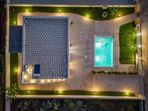 an overhead view of a house with a pool at night at Villa Palibella in Torre Pali 
