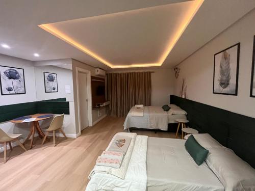 ein Hotelzimmer mit einem Bett und einem Tisch in der Unterkunft Loft Super aconchegante a 50mt da Vila Germânica com estacionamento gratuito in Blumenau