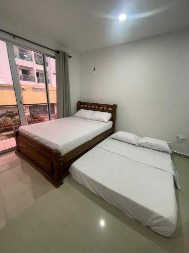 Duplex Castellana 62 Norte Monteria AA في مونتيريا: سريرين في غرفة بها نافذة