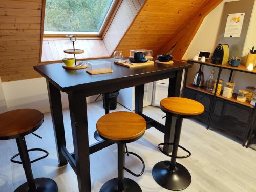シャロン・アン・シャンパーニュにあるChez Lily et Fredの窓のある部屋にある黒いテーブルとスツール