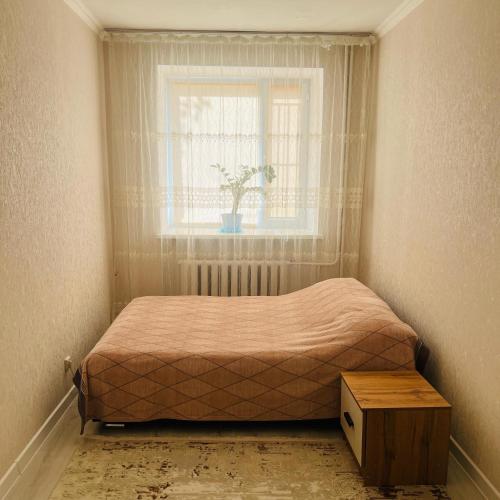 a small bedroom with a bed and a window at 1ком КВ по суточно, по часовой in Koshi