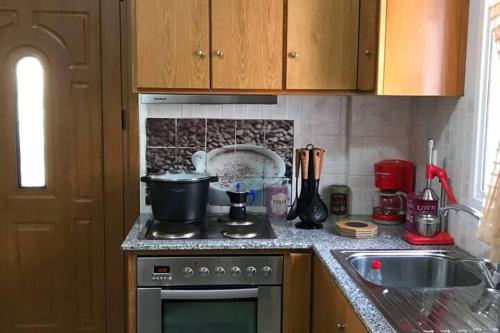 Una encimera de cocina con una estufa y un fregadero. en 1 Bed - Sleeps 2 - Private Balcony - Free Parking, en Masouri