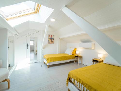 a attic bedroom with two beds and a window at Maison rénovée à Mimizan pour 10 pers. avec jardin proche océan - FR-1-50-194 in Mimizan