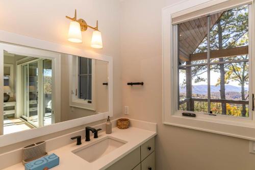 Un baño con lavabo, espejo y ventana. en Blue Meadows at Blue Ridge Mountain Club, en Stony Fork