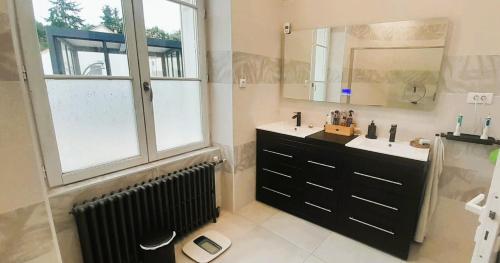 a bathroom with two sinks and a large window at Maison moderne 6 pers Spa privé wifi 14km Beauval in Meusnes