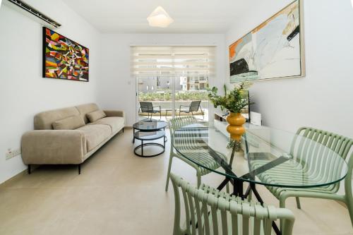 a living room with a glass table and chairs at 1 bedroom flat next to university in Aglantzia