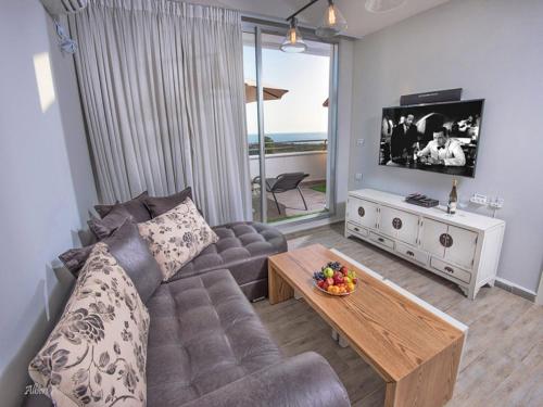 a living room with a couch and a table at Siesta in Achziv in Nahariyya