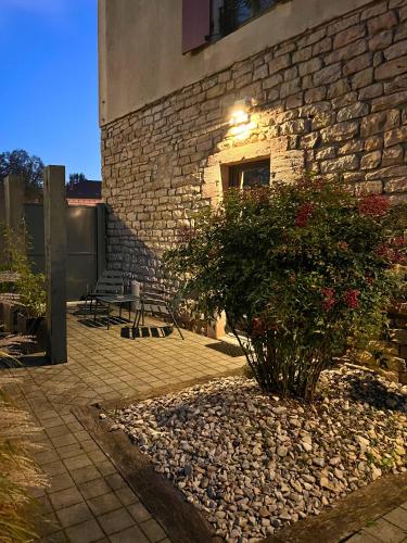 a stone building with a bush in front of a building at Appart Hotel Eugenie in Louhans