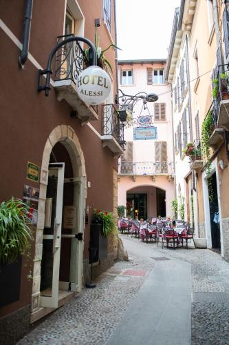 an alley with tables and chairs in a building at Alessi Appartamenti in Desenzano del Garda