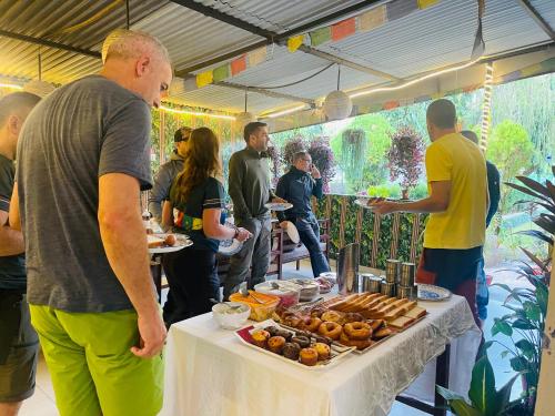 a group of people standing around a table with food at Hotel Peace Ganga Inn in Pokhara