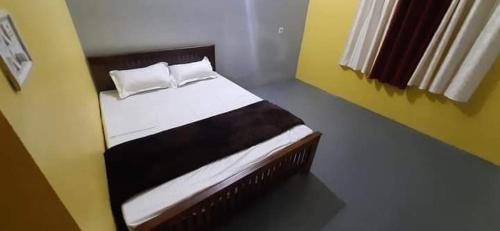 ein Schlafzimmer mit einem Bett mit weißen Laken und Kissen in der Unterkunft Safayar holidays Ramakkalmedu in Ramakkalmedu