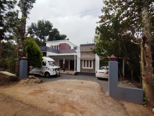 a house with two cars parked in front of it at Safayar holidays Ramakkalmedu in Ramakkalmedu