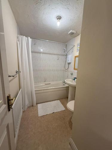 a bathroom with a tub and a toilet and a sink at Beaumont Court in Coventry