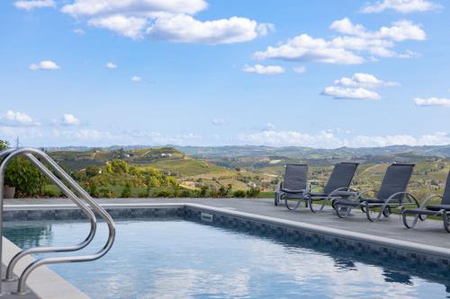 a swimming pool with chairs and a view of the mountains at Casa Nizza D'Oro in Castelnuovo