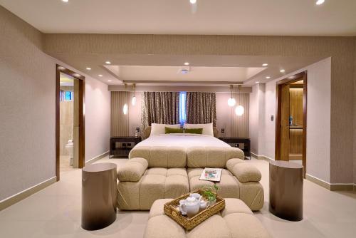 a bedroom with a bed and a couch and a table at Acqualina’s View @ Santo Domingo in El Jobo de Mendoza