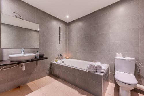 Un baño con bañera, inodoro y lavabo. en Villa Zen, piscine privée et plage, en Casablanca