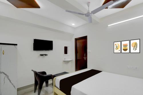 a bedroom with a bed and a ceiling fan at Hotel O De' BVL Grand in Hyderabad