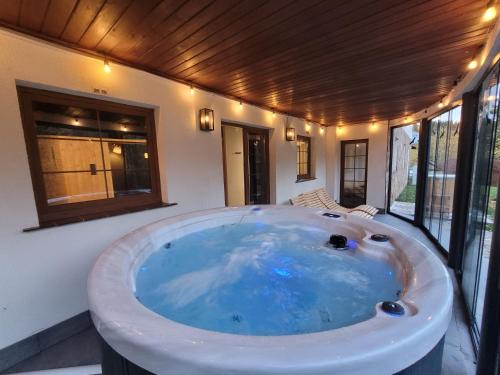 a large bath tub in a room with windows at Domek Górski Czarna Góra in Sienna