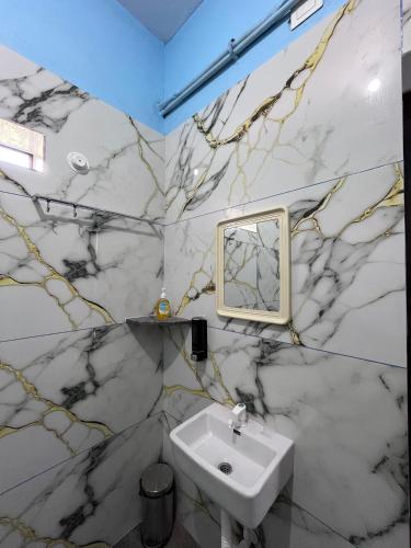 a bathroom with a sink and a mirror at Mantan Stay in Tadri