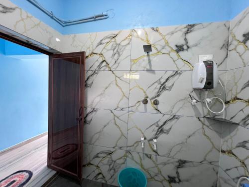 a bathroom with a marble wall at Mantan Stay in Tadri