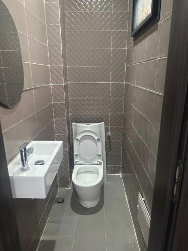 a bathroom with a white toilet and a sink at Résidence Keur Antou in Ziguinchor