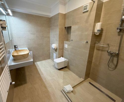une salle de bain avec une douche, des toilettes et un lavabo dans l'établissement Maritimo ApartHotel, à Constanţa