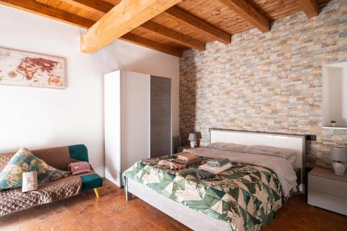 une chambre avec un lit et un mur de briques dans l'établissement Appartamenti in Centro Storico a 15 min Dal Lago d'Iseo - Free Wi-Fi - AC, à Palazzolo sullʼOglio