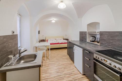 a kitchen with a sink and a bed in a room at Útulný apartmán v srdci Jihlavy in Jihlava