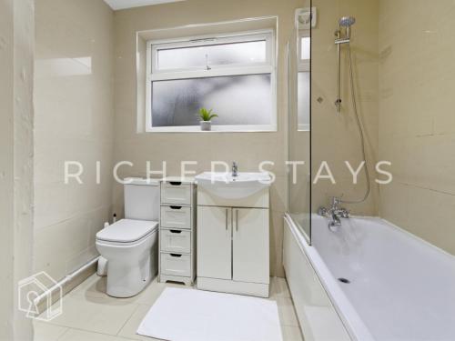 ein Badezimmer mit Toilette, Waschbecken und Badewanne in der Unterkunft Rustic 3BR house in Tilbury, Garden and Parking in Tilbury