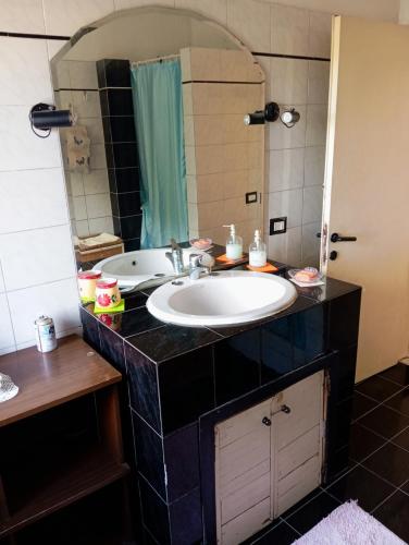 a bathroom with a sink and a mirror at OldHouse in Albergo