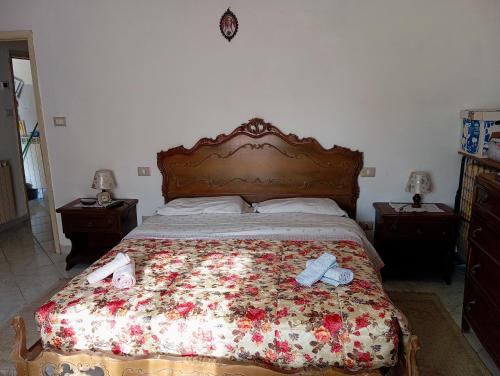 a bedroom with a bed with two shoes on it at OldHouse in Albergo