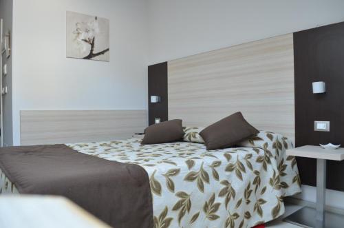 a bedroom with a bed with a large headboard at Hotel Holiday- Alla Finestrella in Bologna