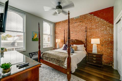 a bedroom with a brick wall and a bed at Luxurious Litfin Loft - Walk to Main St Akron in Akron