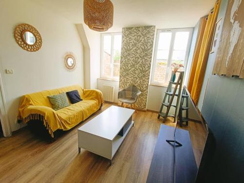 a living room with a yellow couch and a ladder at Le Duplex des Arcades - T2 lumineux hypercentre in Carentan